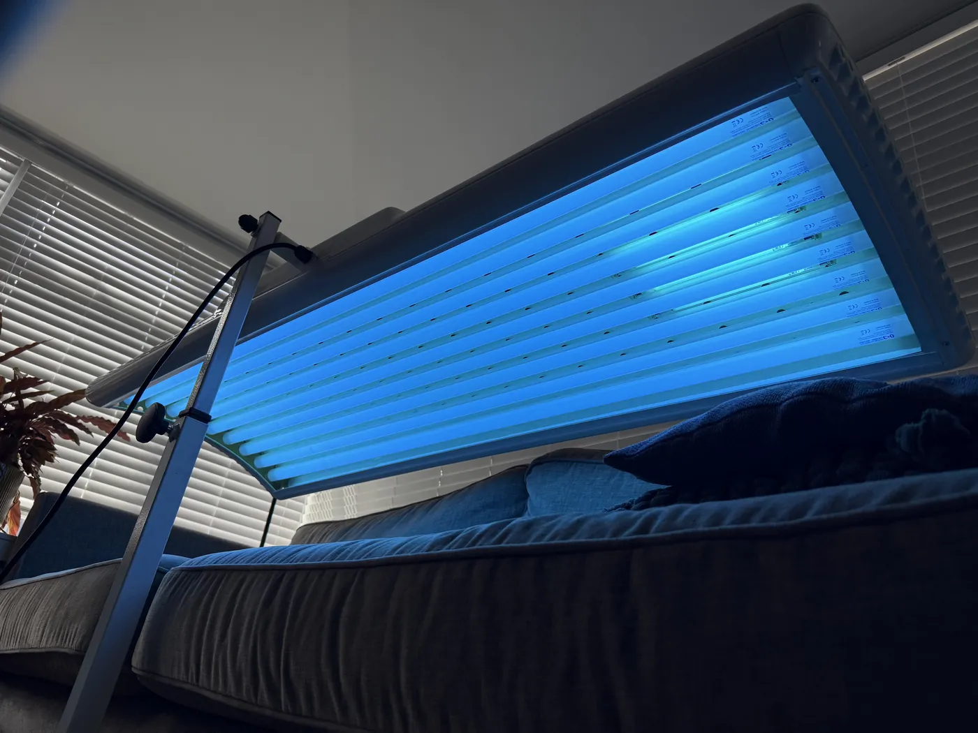 9-Tube Elite Foldaway sunbed lit and positioned over a bed